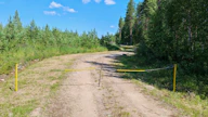 Kuvan metsätien yli vedetty kettinki on merkitty keltaisella huomiovärillä, mutta tien sulkemisesta kertovat liikennemerkit puuttuvat.