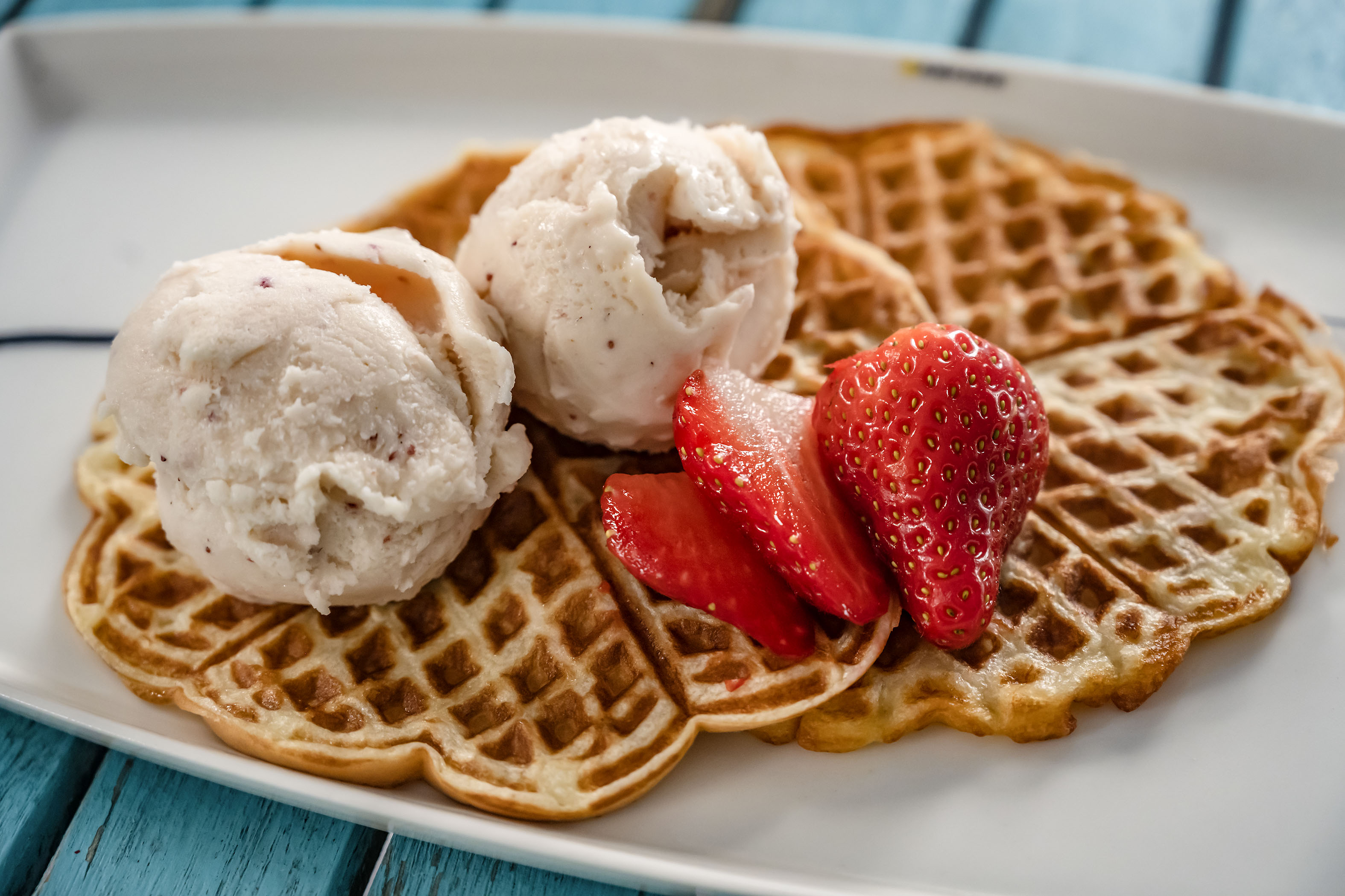 Rapsakoiksi paistetut vohvelit saavat kaverikseen ­vuohenmaitojäätelöä ja mansikoita.