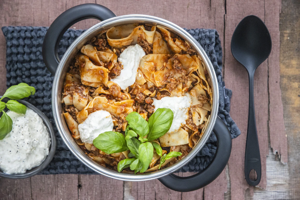 Lasagnen ainekset kypsyvät kattilassa liedellä jo vartissa. Juustoinen jogurttikastike lisätään vasta valmiiseen ruokaan.