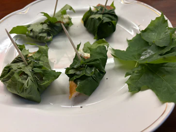 Vaahteranlehdet kätkevät sisäänsä puolikkaan, voidellun varhaisperunan ja lohta savustettuna tillillä, mustapippurilla ja suolalla. 