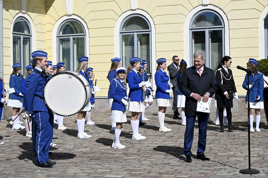 Presidentti Sauli Niinistö ja Rauman Poikasoittokunnan A-puhallinorkesteri Presidentinlinnan pihalla. LEHTIKUVA / EMMI KORHONEN.