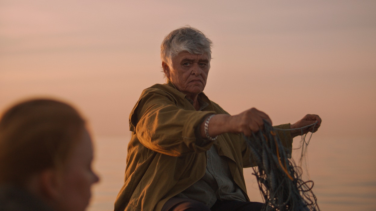 Natalia (Pirkko Saisio) laskee verkkoja veneestä. Etualalla Nora (Alma Pöysti).