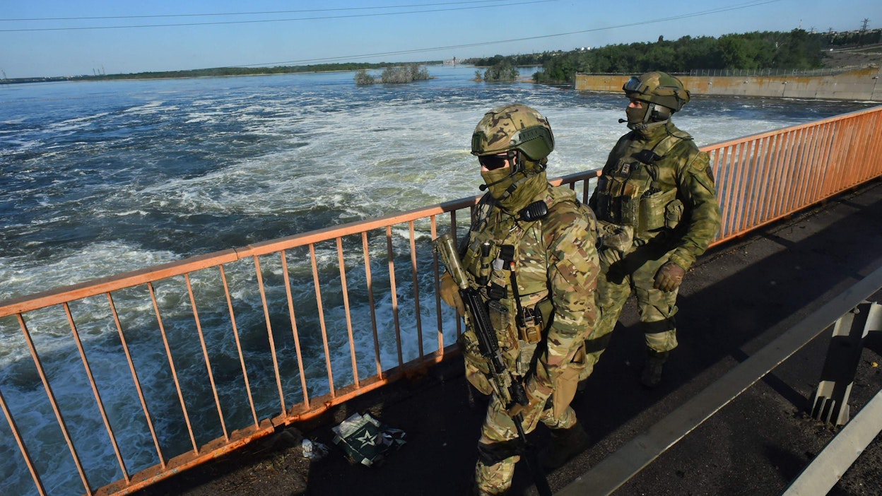 Sosiaalisessa mediassa leviävien videoiden mukaan padosta tulvii runsaasti vettä. Arkistokuvassa venäläisiä sotilaita Kahovkan vesivoimalalla vuonna 2022. LEHTIKUVA / OLGA MALTSEVA. 