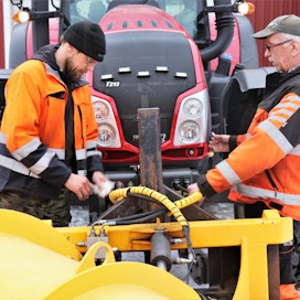 Jukka (vas.) ja Jarmo Majamäki havainnollistavat, kuinka nopeasti lumisina talvina tarvittavien eri aurojen vaihto traktorin nokalle onnistuu.