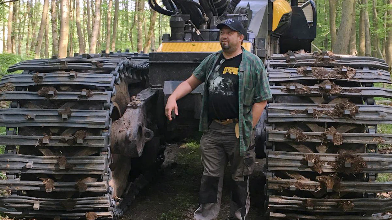 Reima Puutio Ponsse Bear -metsäkoneen telojen välissä. Kone varustettu isolla H8-kouralla.