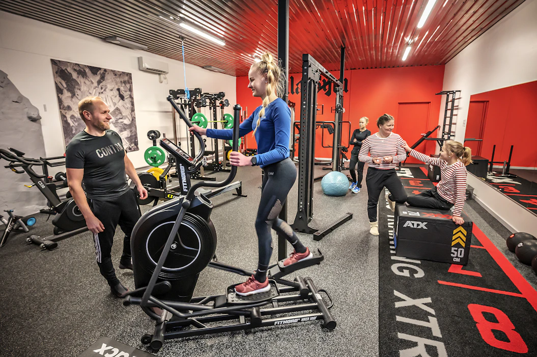 Yli 100-neliöiseltä kotikuntosalilta löytyy kaikki, mitä urheilullinen perhe tarvitsee. Edessä isä Jussi Takala, cross-trainerilla Emma, oikealla äiti Ulla, istumassa Viola ja takana Ilona Takala.