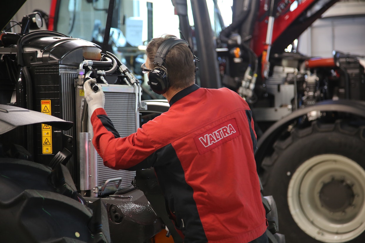 Ohjaamon kiinnittämisen jälkeen valmistuvaan traktoriin kiinnitetään pakokaasun puhdistusjärjestelmä ja jäähdytin myöhemmin asennettavan konepeiton alle. 