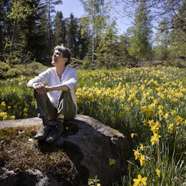Lena Aschan nauttii aurinkoisesta kevätpäivästä narsissien keskellä. 