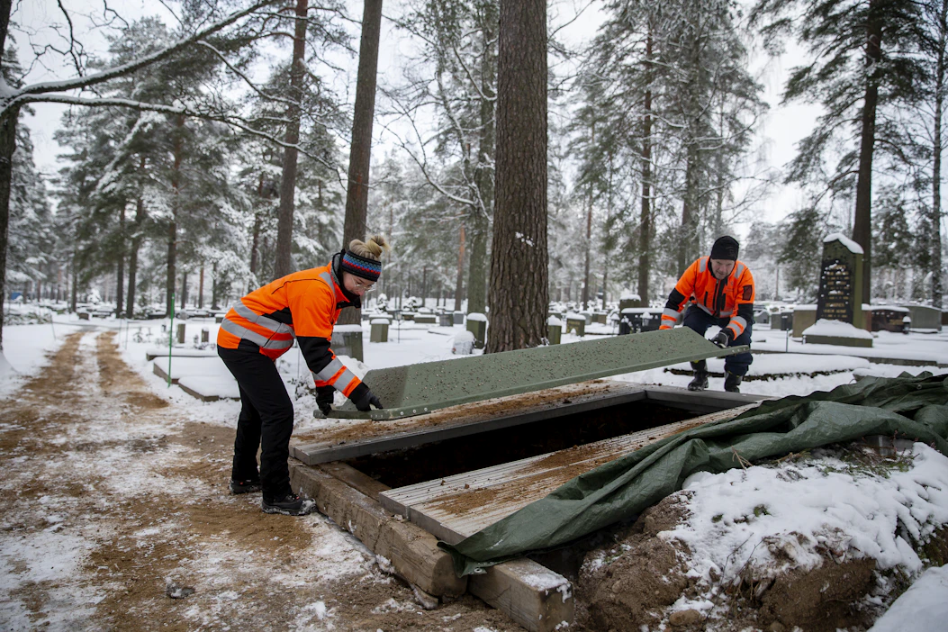 Maan sulattaminen kestää pari päivää, sanoo Tuusulan seurakunnan hautausmaamestari Pasi Hämäläinen (oik.). Työnjohtaja Heini Tarsa auttaa valmiin haudan peittämisessä.