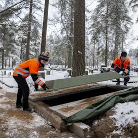 Maan sulattaminen kestää pari päivää, sanoo Tuusulan seurakunnan hautausmaamestari Pasi Hämäläinen (oik.). Työnjohtaja Heini Tarsa auttaa valmiin haudan peittämisessä.