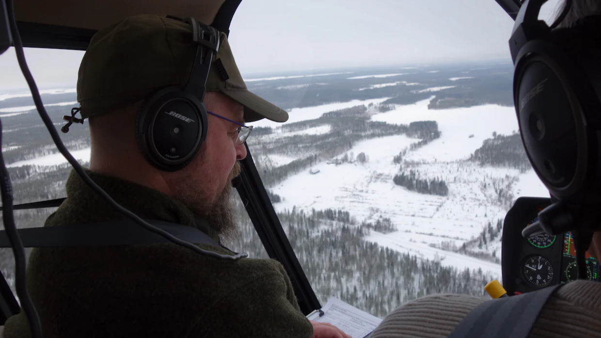 Luken erikoistutkija Antti Paasivaara etsii pannoitukseen sopivaa metsäpeuratokkaa helikopterilla Suomenselän valtionmailta.